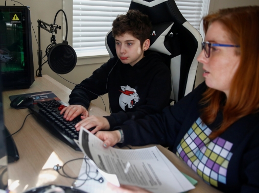 A mother helps her son with a school assignment at their home in Bothell, Washington, March 11, 2020