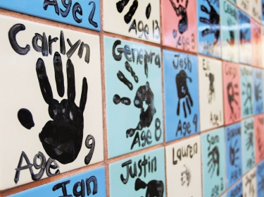 Close up of a colorful tiled wall with children's handprints