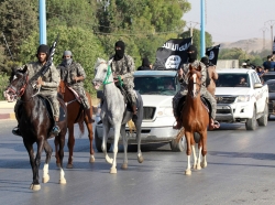 Militant Islamist fighters ride horses in a military parade along the streets of Syria's northern Raqqa province, June 30, 2014
