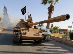Militant Islamist fighters on a tank take part in a military parade along the streets of northern Raqqa province, Syria, June 30, 2014