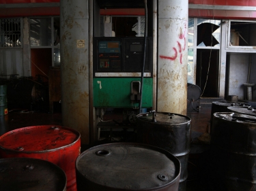 Barrels of fuel are displayed inside a damaged, non-functioning petrol station in Aleppo, Syria, January 13, 2015