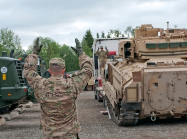 U.S. Army sergeant helps direct an M2A3 Bradley Fighting Vehicle off a flatbed on Tapa Army Base, Estonia, June 4, 2015