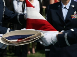 U.S. military personnel fold the American flag at a funeral