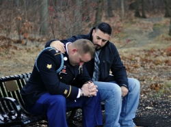 Friend comforts uniformed United States Army soldier sitting on park bench, photo by debbiehelbing/Getty Images
