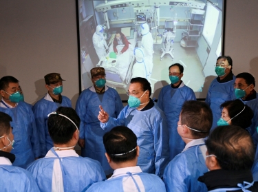 Chinese Premier Li Keqiang wears a mask and protective suit while speaking to medical workers at the Jinyintan hospital, where coronavirus patients are being treated following the outbreak in Wuhan, China, January 27, 2020, photo by cnsphoto via Reuters