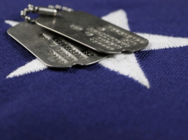 Two military dog tags on an American flag