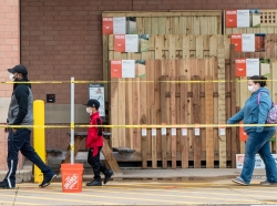 Shoppers line up to enter a Home Depot store as they practice social distancing to help slow the spread of COVID-19 in St. Louis, Missouri, April 4, 2020, photo by Lawrence Bryant/Reuters