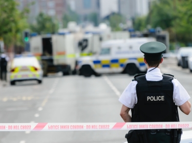 Police officer stands guard at a Police cordon point while army ATOs deal with a suspect bomb, photo by Stephen/Adobe Stock