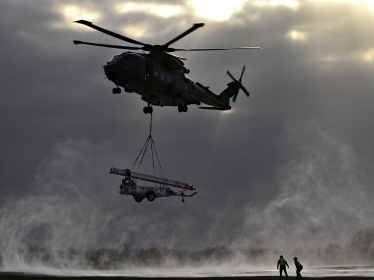 A Merlin helicopter comes in to drop off a Remover 3.1 mast during a snowy morning whilst on a helicopter flight trial at JADTEU, RAF Brize Norton, photo by 1st SAC David Turnbull/Royal Air Force Open Government License