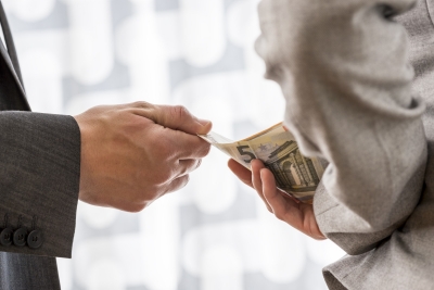 Businessman or politician taking bribe from a colleague handing him Euros