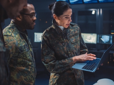 Military personnel meeting in computing facility, photo by Gorodenkoff Productions OU/Adobe Stock