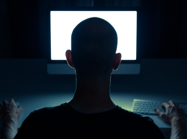 Silhouette of man in front of computer screen, photo by Sander van der Werf/Adobe Stock