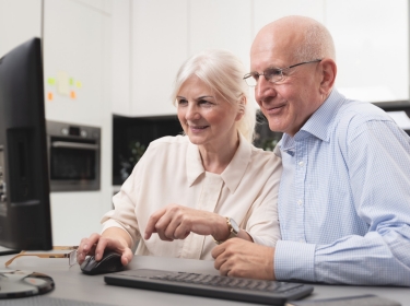 Elder couple work together at computer, photo by Proxima Studio/Adobe Stock
