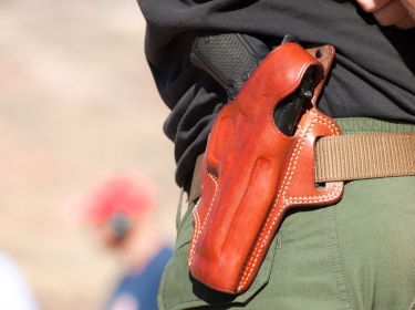 A person wearing a gun in a holster