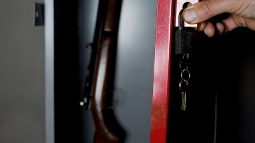 A gun being locked in a safe