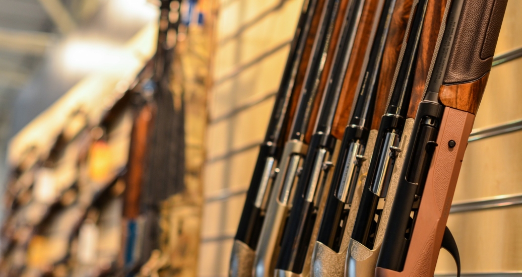 A line of guns on display in a store