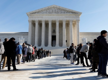 Visitors stand in line outside the U.S. Supreme Court