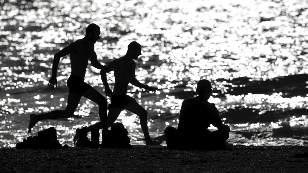 Off-duty Israeli soldiers run on the shore of the Mediterranean sea.