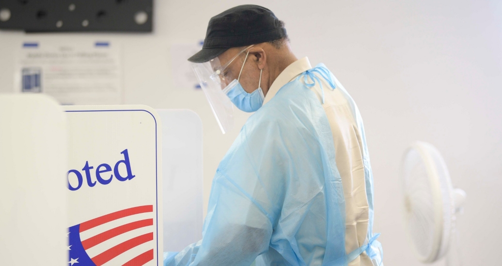 A poll worker disinfects booths after every use during early voting in Knoxville, Tennessee, July 17, 2020