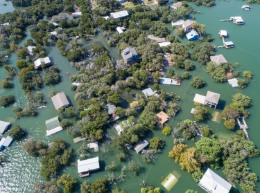 An aerial view of Central Texas homes under water at Graveyard Point neighborhood community in the flood plain of Lake Travis, photo by RoschetzkyIstockPhoto / Getty Images