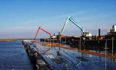 Diggers working from a barge during the Barataria Basin landbridge shoreline protection