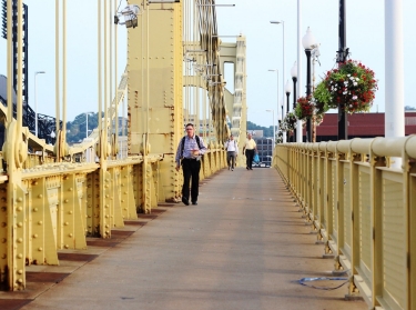 Pedestrians walk across the Roberto Clemente Bridge in Pittsburgh