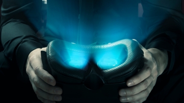 Hands holding virtual reality goggles with light glowing from inside, photo by  Daniel Krasoń / Adobe Stock