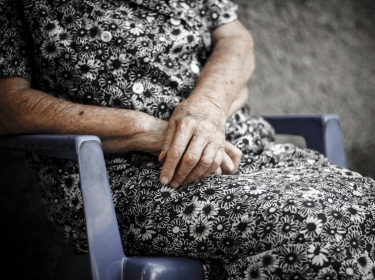 The crossed hands of an elderly woman.